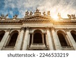 Basilica di San Giovanni in Laterano (Papal Archbasilica of St John Lateran), Rome, Italy. Front view of facade, statues, sky and sun. Concept of sightseeing, tourism, Saint John and Catholic World. 