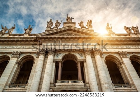 Basilica di San Giovanni in Laterano (Papal Archbasilica of St John Lateran), Rome, Italy. Front view of facade, statues, sky and sun. Concept of sightseeing, tourism, Saint John and Catholic World. 