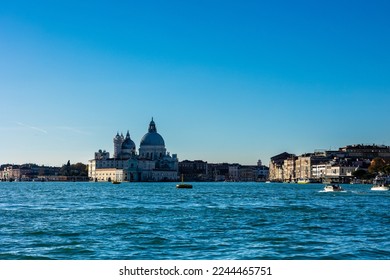 Basilica of Saint Mary of Health (Basilica di Santa Maria della Salute) with Venice canal waters, buildings and gondolas during winter 2022