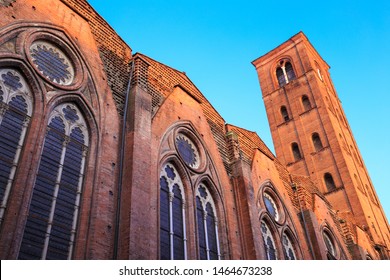 Basilica of San Petronio (Basilica Di San Petronio)in Bologna, Italy - rear part with the tower - at sunset, illuminated by the last rays of golden light, under clear blue sky.