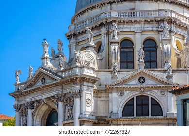 Basilica of Santa Maria della Salute on Grand Canal in summer, Venice, Italy. The architecture detail with statues on the facade. Santa Maria della Salute is one of the best-known sights of Venice.