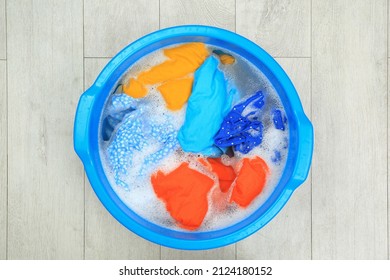 Basin with colorful clothes on floor, top view. Hand washing laundry - Powered by Shutterstock