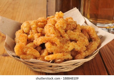 A Basked Of Deep Fried Breaded Clam Strips With A Mug Of Beer