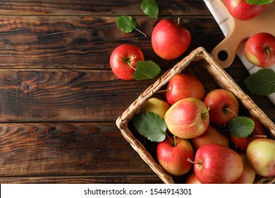 Basket with apples on wooden background, copy space