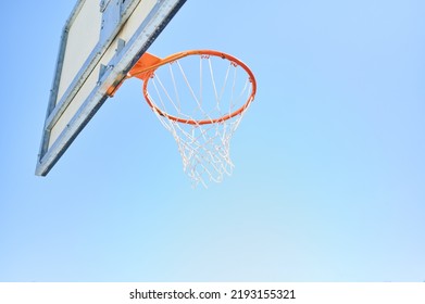 Basket background with copy space. Backboard and basket with net of a basketball court seen from behind.