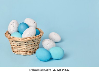 Basket of blue and white easter eggs on pastel background