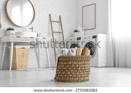 Basket with clean bed sheets in laundry room