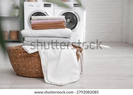 Basket with clean bed sheets in laundry room