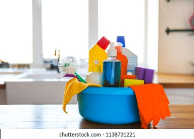 Basket with cleaning items on blurry background white citchen. Cleaning concept. Set with copy space. - Shutterstock ID 1138731221