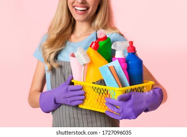 Basket Of Cleaning Supplies, Close Up. Happy Housewife In Apron And Purple Rubber Gloves, Cropped