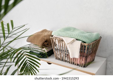 Basket with clothes on chest of drawers in room