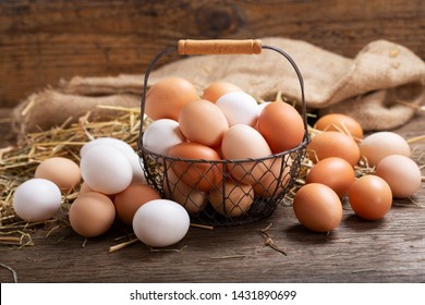 basket of colorful fresh eggs on wooden background 