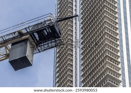 Basket of a Construction Crane in Front of a High Rise Building in Dowtown Toronto
