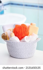 Basket With Cosmetic Products And Bath Accessories On Table