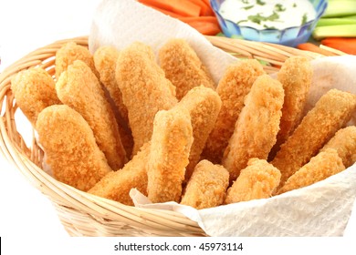 A Basket Of Crispy Chicken Fingers With Platter Of Vegetables And Ranch Dip On A White Background