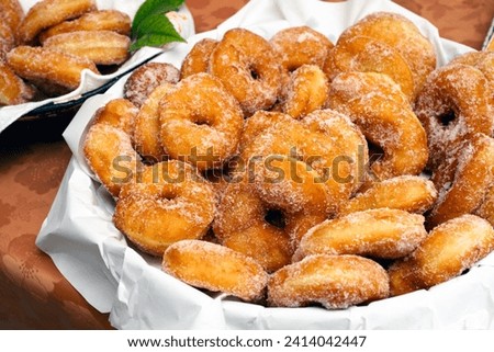 Basket with delicious fatti fritti, traditional fried donuts produced in Sardinia, typical carnival dessert, Italian food
