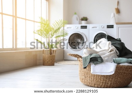 Basket with dirty clothes in laundry room