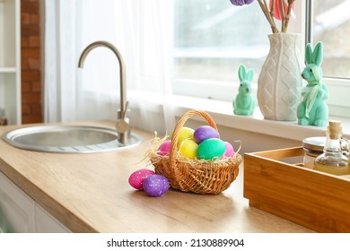 Basket With Easter Eggs On Wooden Kitchen Counter Near Window