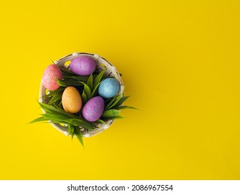 Basket with easter eggs  on yellow spring background. Hello spring and easter concept.  colorful eggs. Flat lay, top view