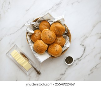 A basket filled with warm, golden-brown dinner rolls, wrapped in a linen cloth. Perfect for holiday feasts, family meals, or comforting baked goods themes.               - Powered by Shutterstock