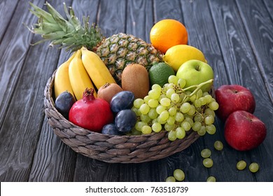 Basket and fresh fruits on wooden table