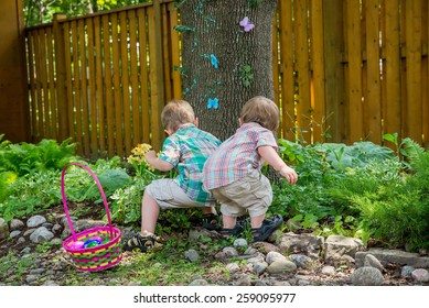 A basket full of colorful eggs sits beside two boys finding eggs during an Easter egg hunt outside in a beautiful garden in the spring.  Part of a series. - Powered by Shutterstock