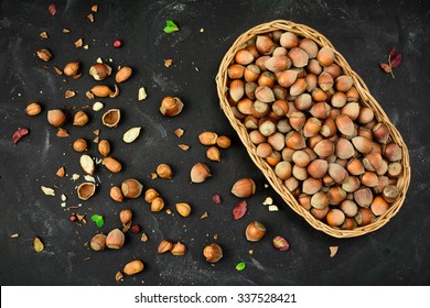 Basket of Hazelnuts in a nutshell, cracked nuts, autumn leaves, grunge background. Top view. 