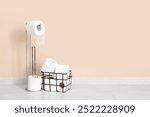 Basket and holder with toilet paper rolls near color wall