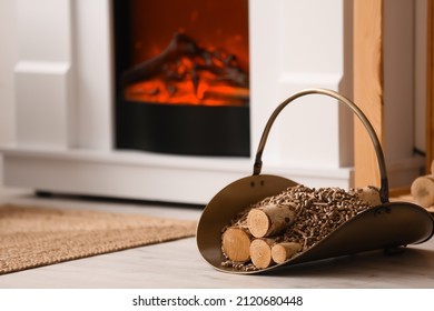 Basket with pellets and firewood near mantelpiece in living room