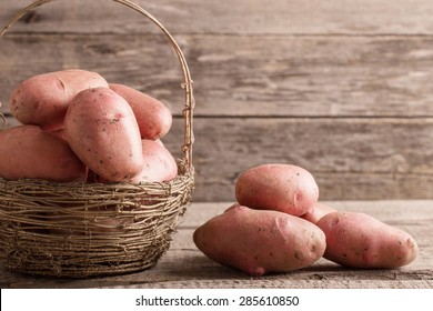 Basket With Red Potatoes On Wooden Background