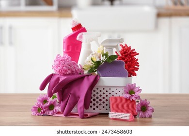 Basket with set of cleaning supplies and spring flowers on wooden table in kitchen - Powered by Shutterstock