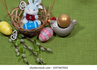In the basket sits a hare with an Easter egg. On the edge of the basket are clothespins with the letters 