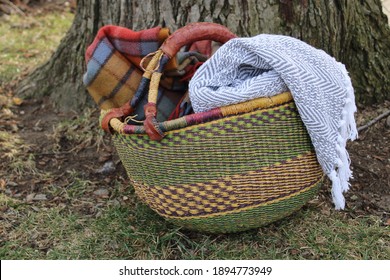 Basket of throw blankets by tree