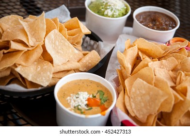 Basket Of Tortilla Chips, Queso, Guacamole And Salsa