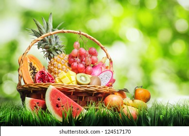 Basket of tropical fruits on green grass. - Powered by Shutterstock