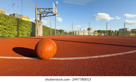 Basketball ball on the ground. Close-up ball on the red court. Basketball on the street or indoor court. Sports gear without people. Minimalism. Template, sport background  - Powered by Shutterstock