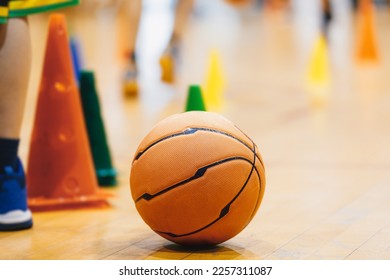 Basketball ball and training cones. Basketball training equipment at training session. Players at practice unit in blurred baskground. School basketball training session - Powered by Shutterstock