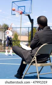 A Basketball Coach Or Scout Recruiter Observes An Athlete While He Warms Up.