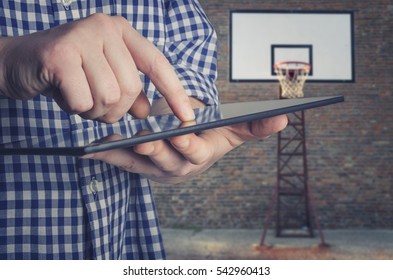 Basketball coach using a digital tablet on the basketball court. Game Plan Tactics Concept - Powered by Shutterstock