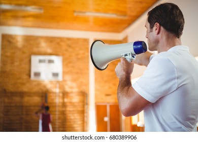 Basketball coach using megaphone in court - Powered by Shutterstock