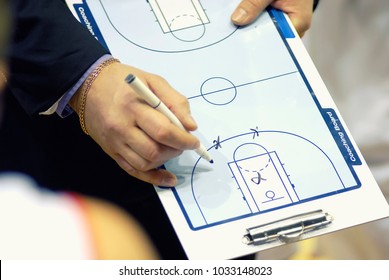 Basketball coach write tactics on coaching board - Powered by Shutterstock