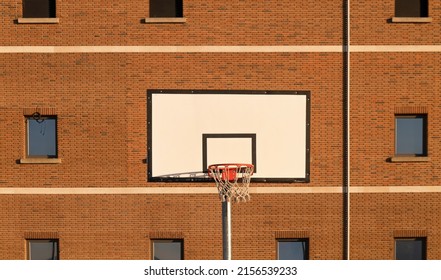 Basketball hoop against building with windows - Powered by Shutterstock