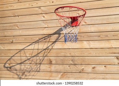 Basketball hoop hanged on wooden board background. Playground on backyard of home. Sport equipment for children
