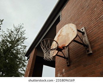 Basketball hoop and net installed on the school wall outside - Powered by Shutterstock