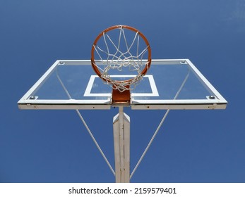 Basketball hoop with net on an outdoor court with sky background, view from below - Powered by Shutterstock