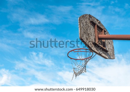 Basketball hoop on blue sky with clouds background
