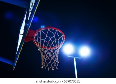 Basketball Hoop On Outdoor Sport Court At Night With Lens Flare