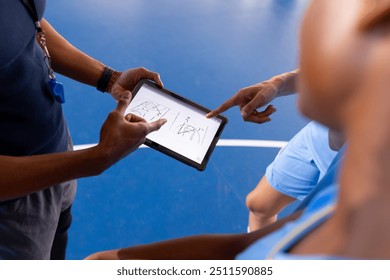 Basketball male coach using tablet to discuss game strategy with players. team, technology, discussion, sports - Powered by Shutterstock