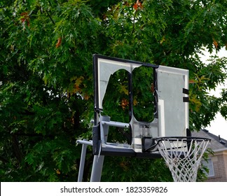 Basketball Net With Broken Backboard In Front Of Greens Trees