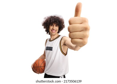 Basketball player holding a ball and gesturing thumbs up isolated on white background
